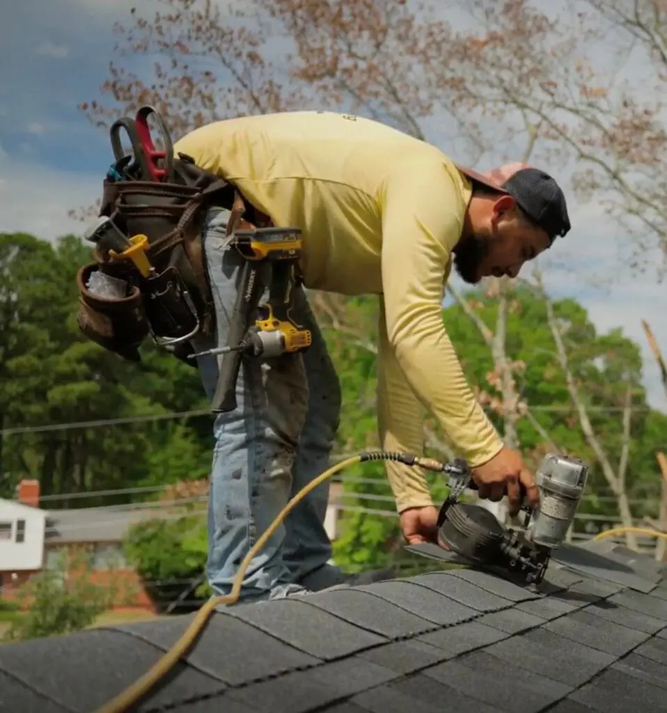 A bumble roofing roofer nailing down new shingles